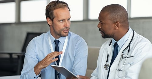 Two doctors in conversation with a tablet