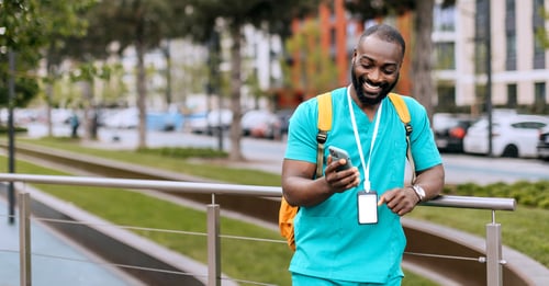 Male healthcare worker smiling at phone