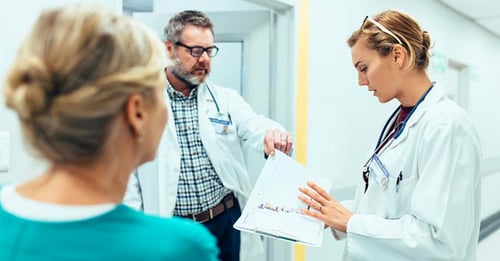 Group of 3 medical professionals reviewing documents