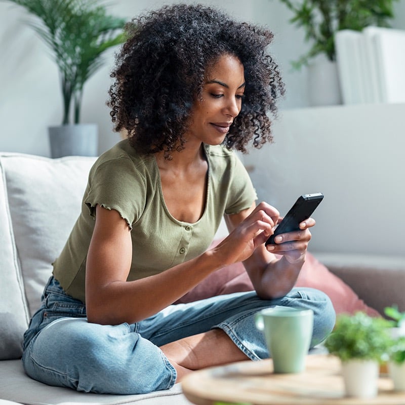 Woman on couch on phone in living room reduced for web